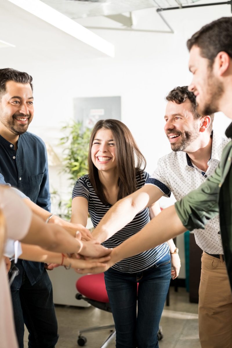 Business team putting their hands together in cooperation and success